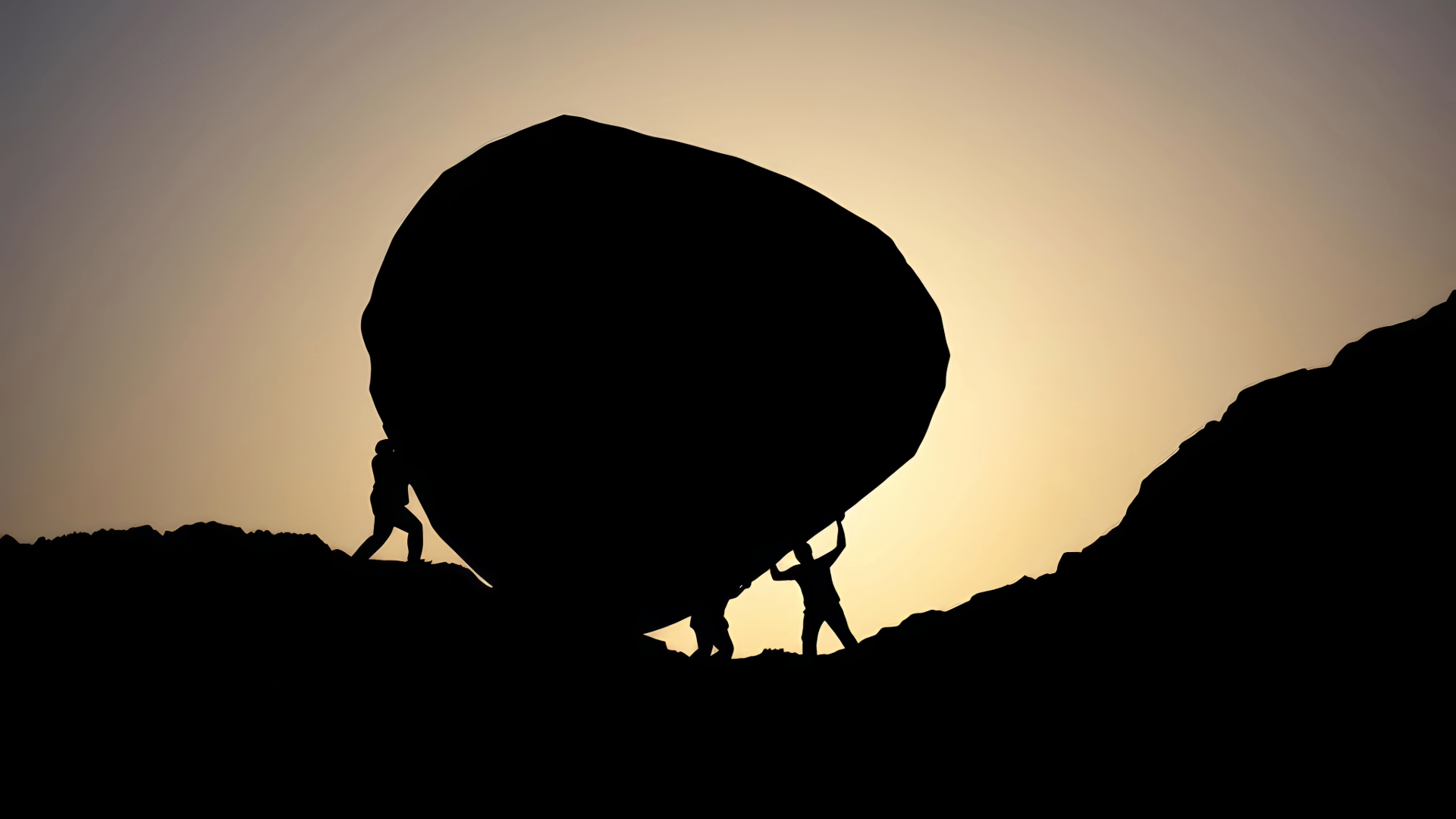 People helping each other move a boulder
